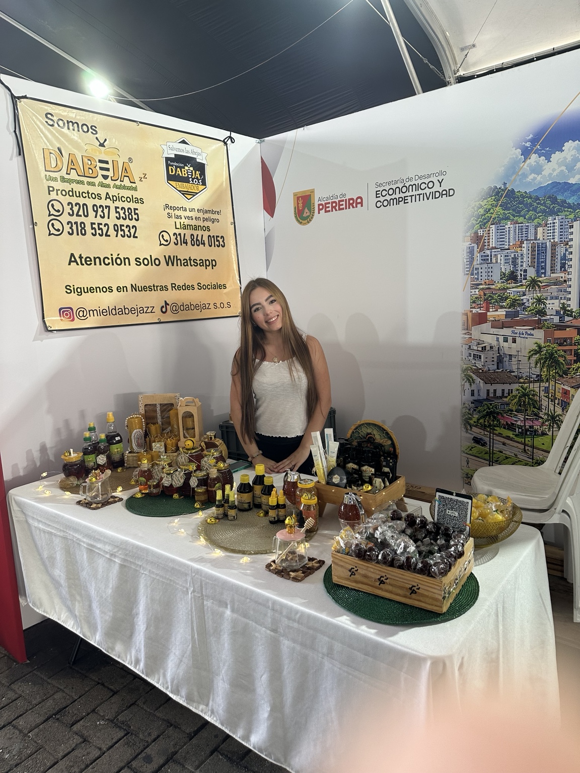 Emprendedora junto a productos apícolas y miel.
